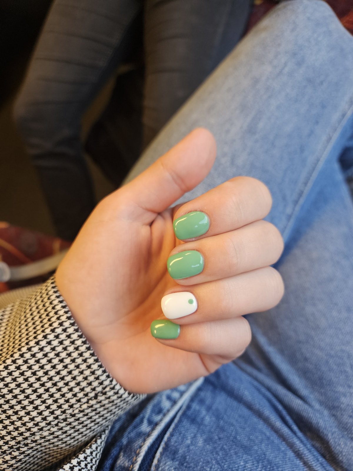 Hand met mintgroene nagels en één witte accentnagel